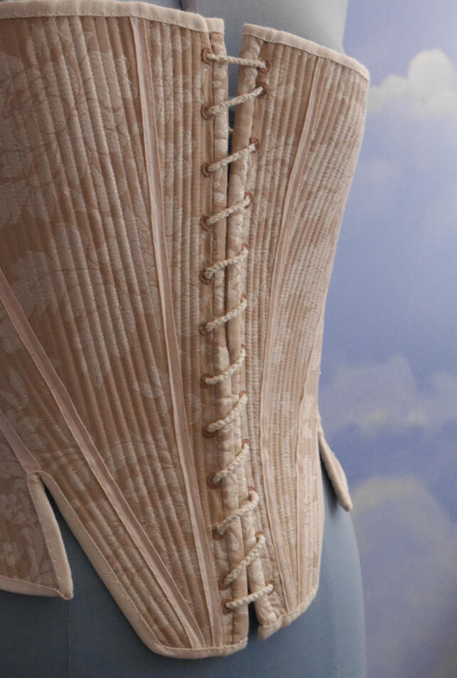 Détails d&#39;un corps baleiné 1720-1730 Tissu damassé, ruban de soie et droit-fil en coton, baleiné au rotin, lacets tissés aux doigts